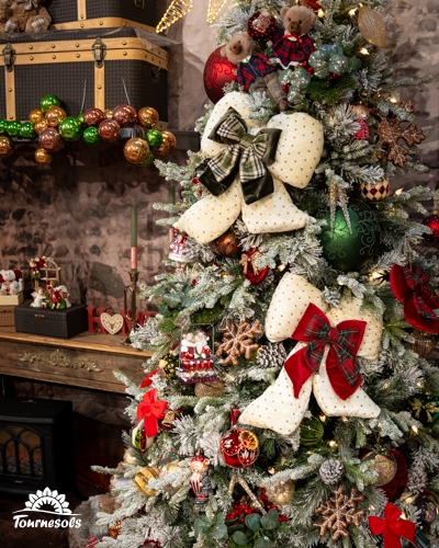Sapin de Noël décoré avec des boules et des rubans dans un style country.